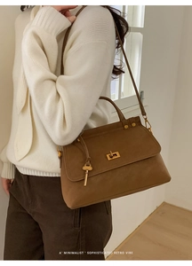 Brown suede crossbody bag shown on a model with minimalist retro vibes and gold hardware