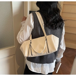 Detail shot of cream white PU leather shoulder bag with decorative metal chain and zippers