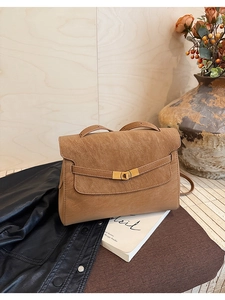 Close-up of the vintage brown textured leather tote bag with elegant gold metal twist lock