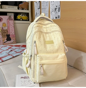 Détail d'un sac à dos scolaire beige à motifs d'étoiles dans une chambre confortable