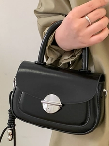 Minimalist black glossy leather square shoulder bag with silver metal buckle on hand