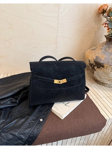 Detailed view of black vintage tote bag with metal turn-lock and matte leather finish