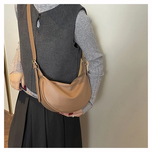 Detailed texture of brown lychee-patterned crescent hobo bag with gold metal hardware
