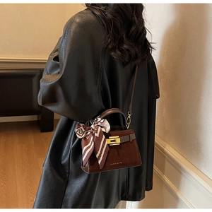 Detail of a brown trapezoid crossbody bag with suede-leather mix and silk scarf