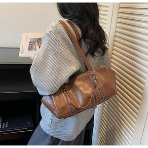 Detailed side view of vintage brown leather shoulder bag with chic metal chain accent