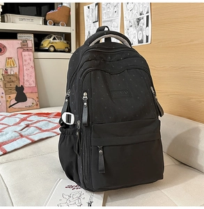 Détail du sac à dos noir avec motif d'étoiles et poche latérale avec cordon de serrage