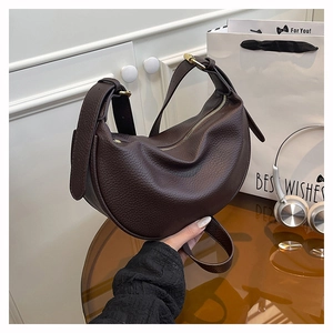 Detail of dark brown lychee leather hobo bag with gold buckle and adjustable strap