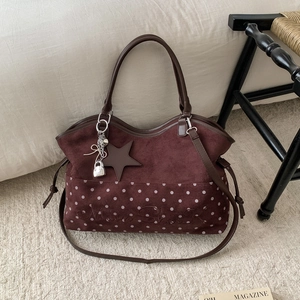 Dettaglio borsa tote bordeaux a pois bianchi con ciondolo a stella e logo Moon Shark