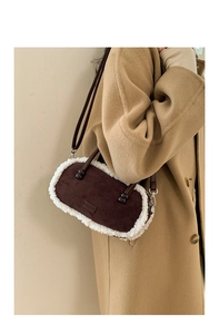 Détail du sac bowling en daim marron avec bordure en fausse fourrure blanche et patch mode