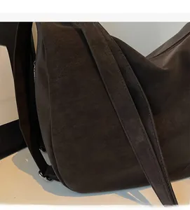 Detailaufnahme der Wildleder-Textur und des breiten Schultergurts der Vintage-Tasche