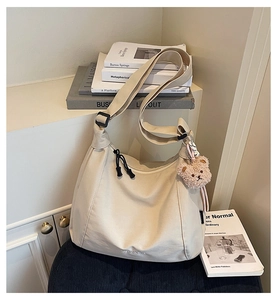 Detailed close-up of beige canvas tote bag with adjustable strap and Madison branding