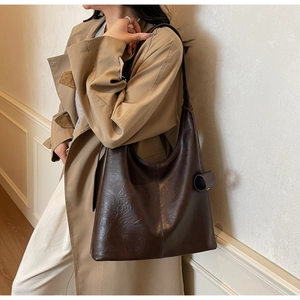 Close-up of a large dark brown hobo bag showing retro oiled leather texture on shoulder