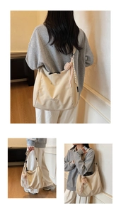 Détail du sac cabas beige avec breloque ours, ruban rayé et broderie logo élégante