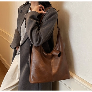 Detail view of brown vintage PU leather tote bag with wide strap and side stitching