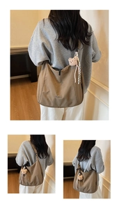Détail d'un grand sac hobo en toile marron avec logo brodé et pendentif ours en peluche