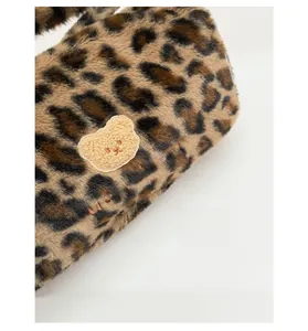 Détail du tissu peluche léopard avec broderie ours mignon et texte sur sac en fausse fourrure