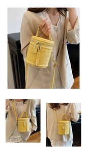 Detail view of yellow quilted bucket bag with cartoon charms and detachable strap