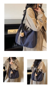 Détail du sac hobo en toile marine avec broderie et accessoire de charme d'ours en peluche