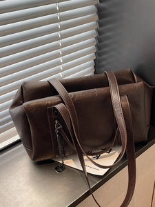 Dark brown retro shoulder bag in glossy leather with heart charm and metal chain detail