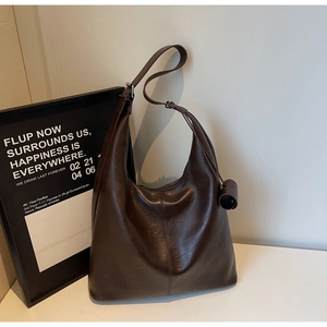 Detail of dark brown leather hobo bag with oil-wax finish and adjustable strap