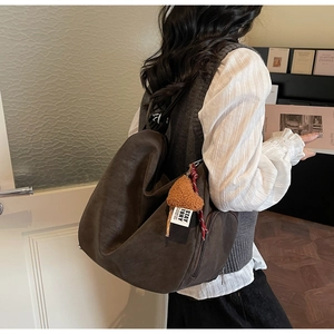 Détail du sac cabas vintage marron avec pendentif ours et fermeture éclair latérale