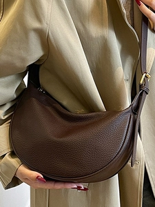 Deep brown crescent crossbody bag in pebble grain leather with an adjustable strap