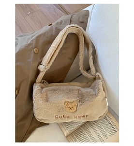 Détail du sac cylindre en peluche beige avec broderie d'ours mignon sur tissu