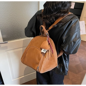 Détail du sac à dos vintage en cuir PU marron avec pendentifs cœur et corde tressée