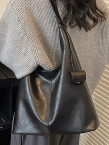 Large black minimalist leather tote bag for women with cylinder charm for winter commuting