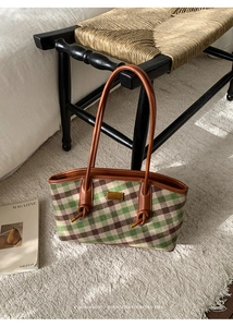 Détail du cabas à carreaux vintage avec lanières en cuir marron et plaque en métal doré
