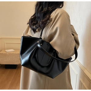Schwarze glänzende große Tote Bag kombiniert mit khakifarbenem Trenchcoat für Winter-Looks