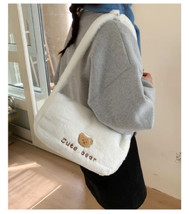 Détail du sac à bandoulière en peluche blanche avec broderie ours et texture douce