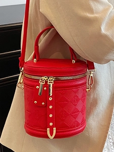 Fashionable red quilted cylinder bucket bag with gold studs and top handle strap