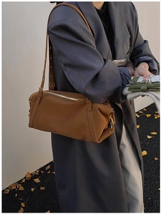 Detail of caramel leather shoulder bag with gold hardware and adjustable strap