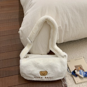 Détail du sac à épaule blanc en peluche avec patch ours mignon et texture douce