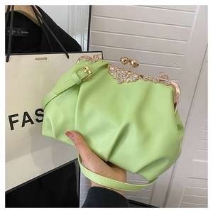 Détail du sac plissé vert avec fermoir floral en strass et texture en cuir PU souple