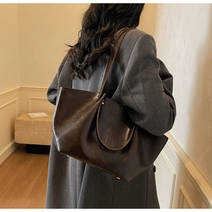 Detailansicht der großen dunkelbraunen Ledertasche mit Vintage-Textur und Doppelriemen
