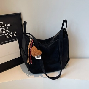 Gros plan d'un grand sac cabas noir avec fermeture éclair et pendentif en cœur