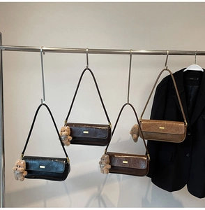 Detail view of retro baguette bags in four colors with gold bar and plush bear charm