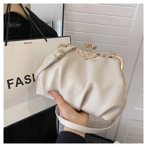 Détail du sac beige plissé avec fermoir vintage doré orné de cristaux en oiseau