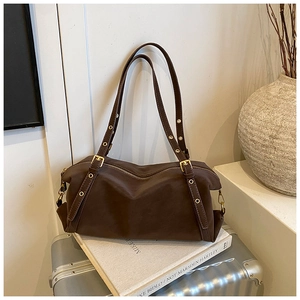 Detailed view of dark brown retro shoulder bag with metal eyelets and adjustable straps