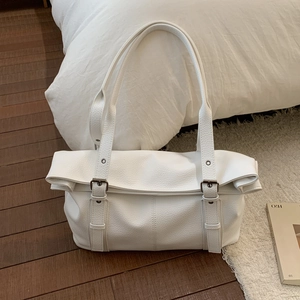 Close-up of white lychee texture leather tote bag with elegant metal buckle details
