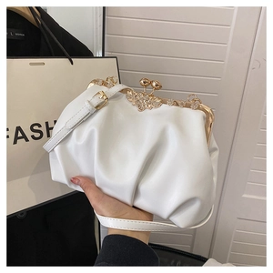 Détail du sac plissé blanc avec fermoir doré et décoration de papillon en strass chic