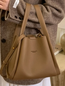 Vintage brown textured leather bucket bag with top handles and adjustable strap for women