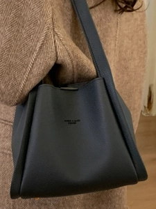Vintage navy blue leather bucket tote bag styled with a brown herringbone wool coat