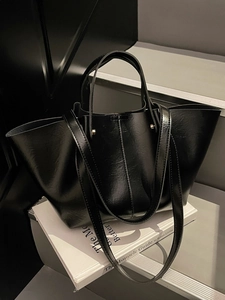 Schicke schwarze Shopper-Tasche aus glänzendem Leder mit Griffen und Schultergurt
