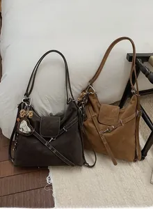 Gros plan de sacs cabas vintage avec texture grainée et breloques décoratives en cœur