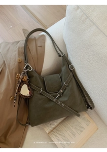 Détail d'un sac cabas en cuir mat olive avec un pendentif miroir léopard en forme de cœur