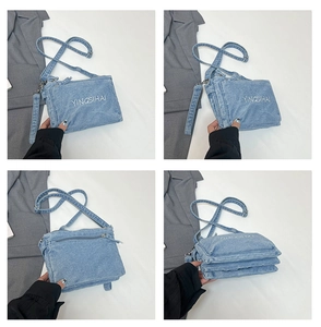 Detail view of light blue denim shoulder bag showing multi-layer gusset design and YINGSIHAI embroidery