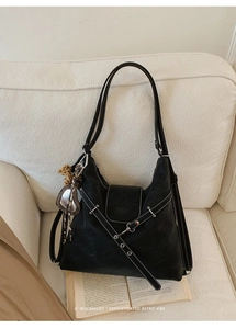 Détail du sac cabas vintage noir avec coutures contrastées et pendentif léopard en cœur